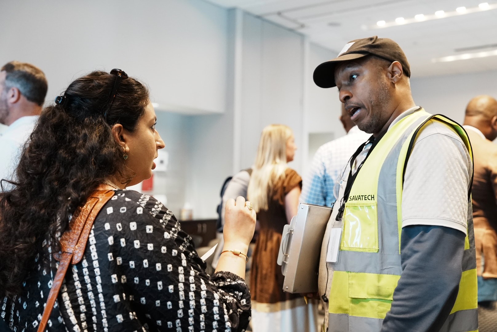 A trade professional speaks with a project representative after the presentation