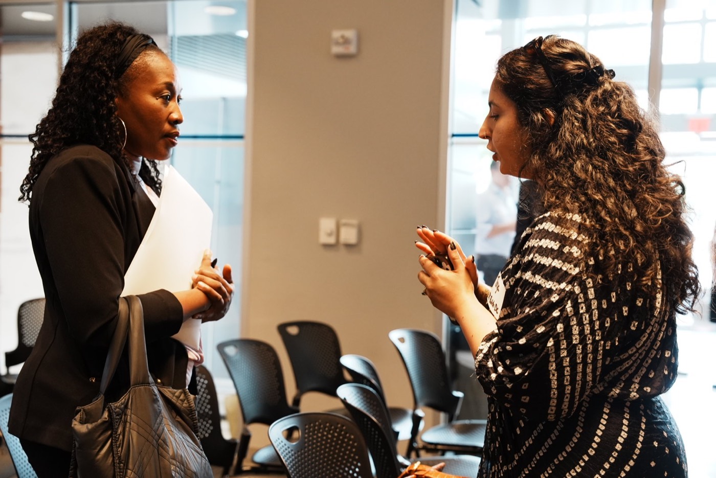 Two attendees continue a conversation after the formal presentation